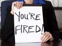 Person holding a sign reading "You're Fired"